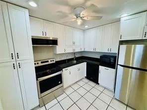 a kitchen with a sink appliances and cabinets
