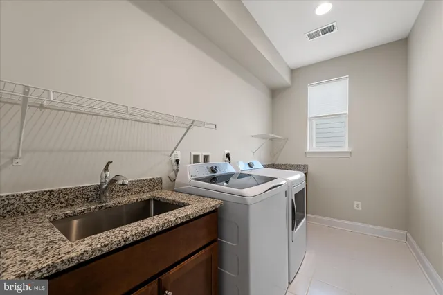 a utility room with sink dryer and washer