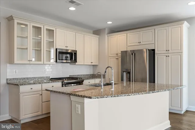 a kitchen with stainless steel appliances granite countertop a refrigerator sink and cabinets