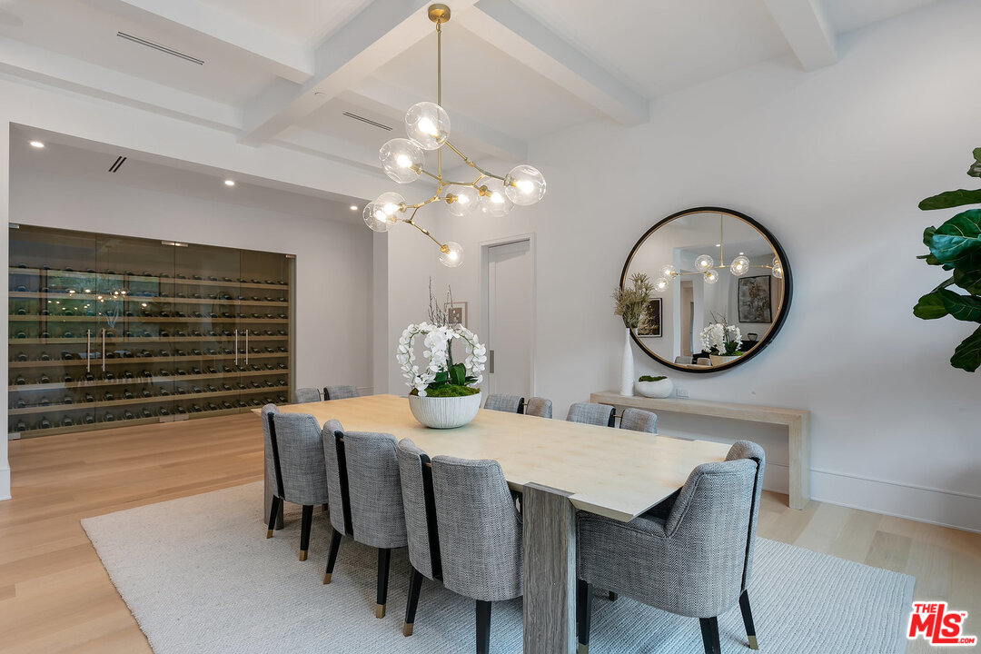 25211 Jim Bridger Road Hidden Hills, CA 91302 - Photo 13 of 42 a dining room with wooden floor a chandelier a wooden table and chairs