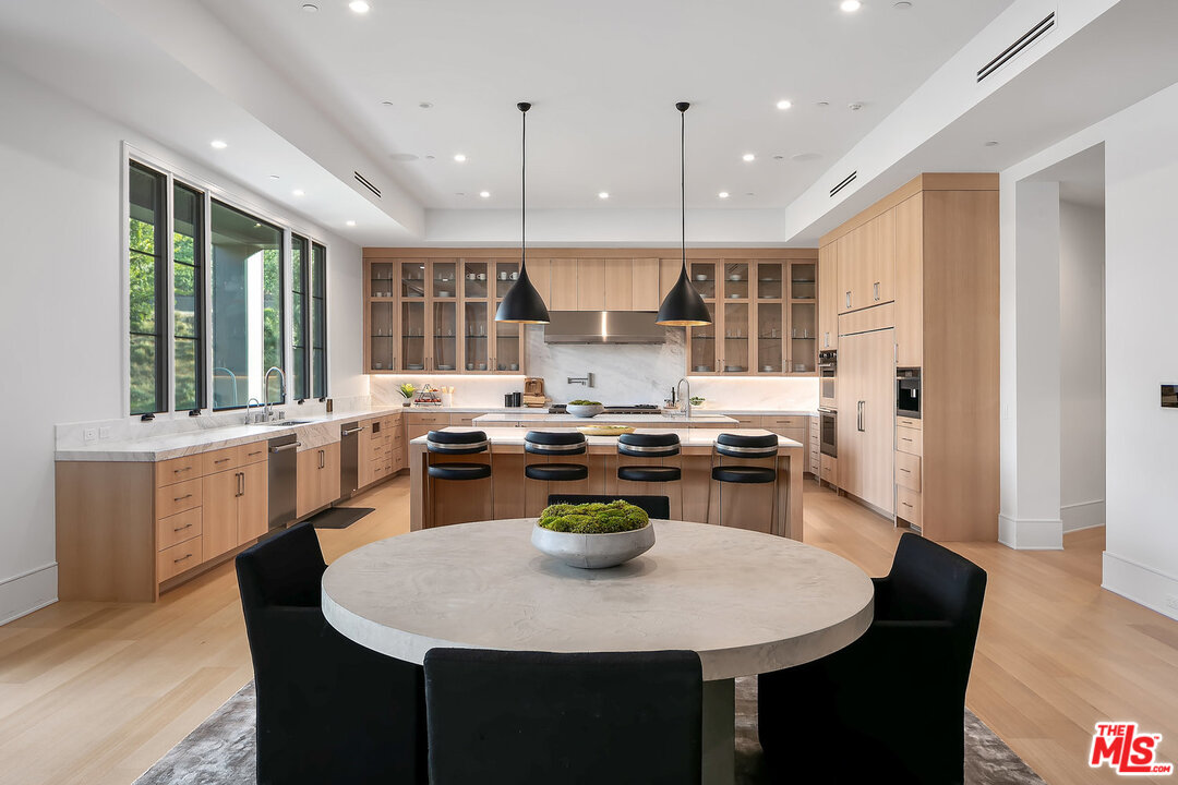 25211 Jim Bridger Road Hidden Hills, CA 91302 - Photo 16 of 42 a kitchen with a table chairs stove and kitchen island