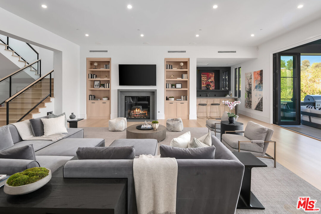 25211 Jim Bridger Road Hidden Hills, CA 91302 - Photo 18 of 42 a living room with fireplace furniture and a flat screen tv