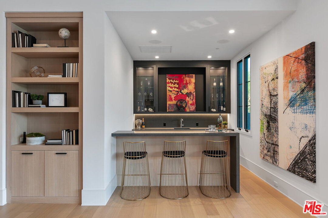 25211 Jim Bridger Road Hidden Hills, CA 91302 - Photo 20 of 42 a living room with furniture a flat screen tv and a bookshelf