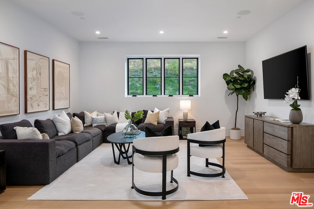 25211 Jim Bridger Road Hidden Hills, CA 91302 - Photo 24 of 42 a living room with furniture a flat screen tv and a large window