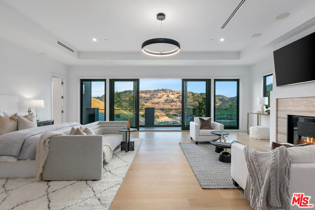 25211 Jim Bridger Road Hidden Hills, CA 91302 - Photo 25 of 42 a living room with fireplace furniture and a flat screen tv