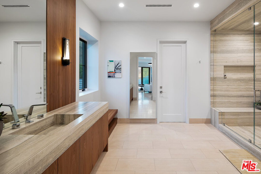25211 Jim Bridger Road Hidden Hills, CA 91302 - Photo 30 of 42 a spacious bathroom with a granite countertop sink and a mirror