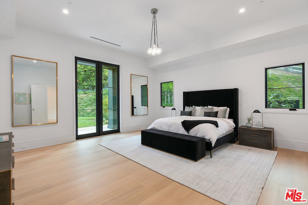 25211 Jim Bridger Road Hidden Hills, CA 91302 - Photo 34 of 42 a bedroom with a large bed and a large window