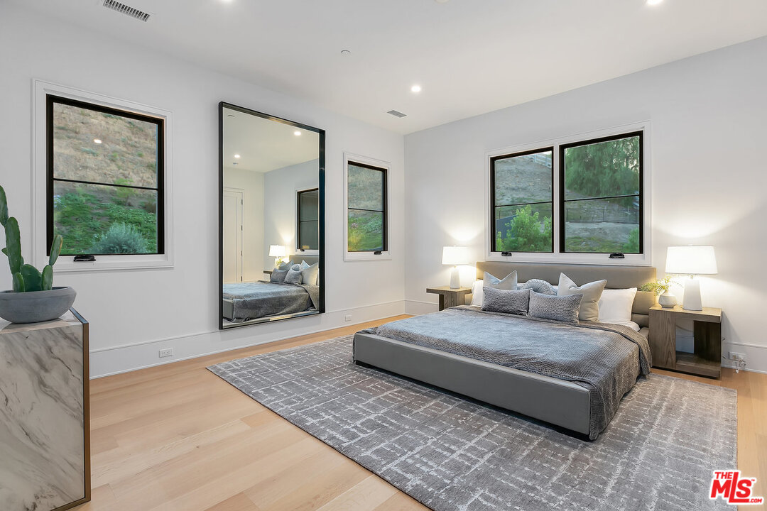 25211 Jim Bridger Road Hidden Hills, CA 91302 - Photo 35 of 42 a bedroom with a large bed couch and a large window