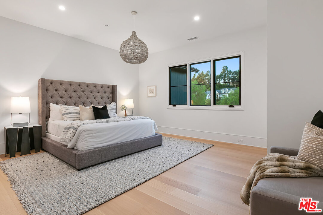 25211 Jim Bridger Road Hidden Hills, CA 91302 - Photo 37 of 42 a bedroom with a large bed and a window