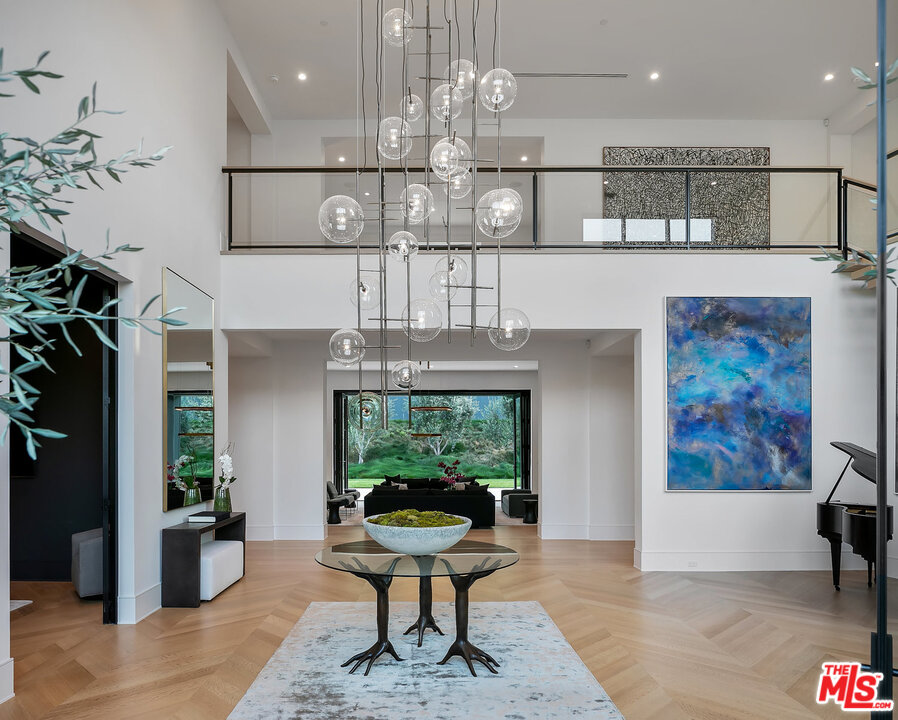 25211 Jim Bridger Road Hidden Hills, CA 91302 - Photo 6 of 42 a view of a dining room with furniture a kitchen and chandelier