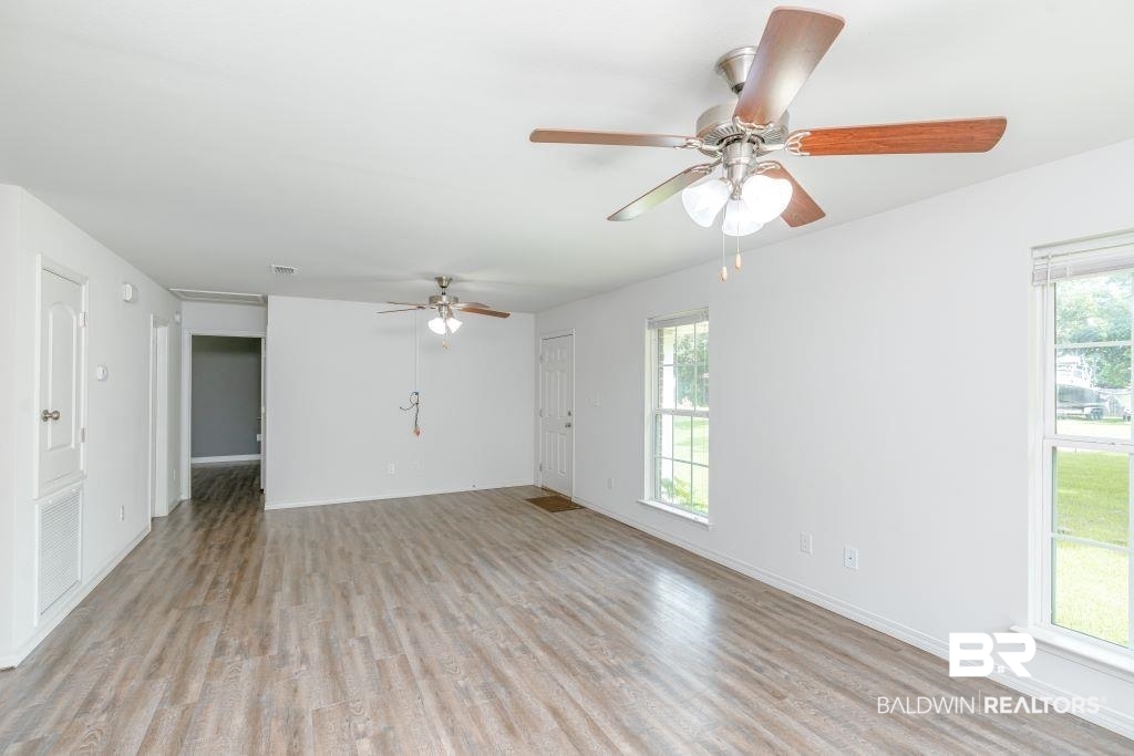 12641 Pecan Street Grand Bay, AL 36541 - Photo 7 of 23 Empty room with plenty of natural light, light hardwood / wood-style flooring, and ceiling fan