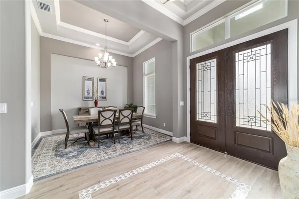 a large kitchen with kitchen island a dining table chairs and white cabinets