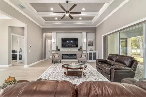 a living room with furniture a fireplace and a chandelier