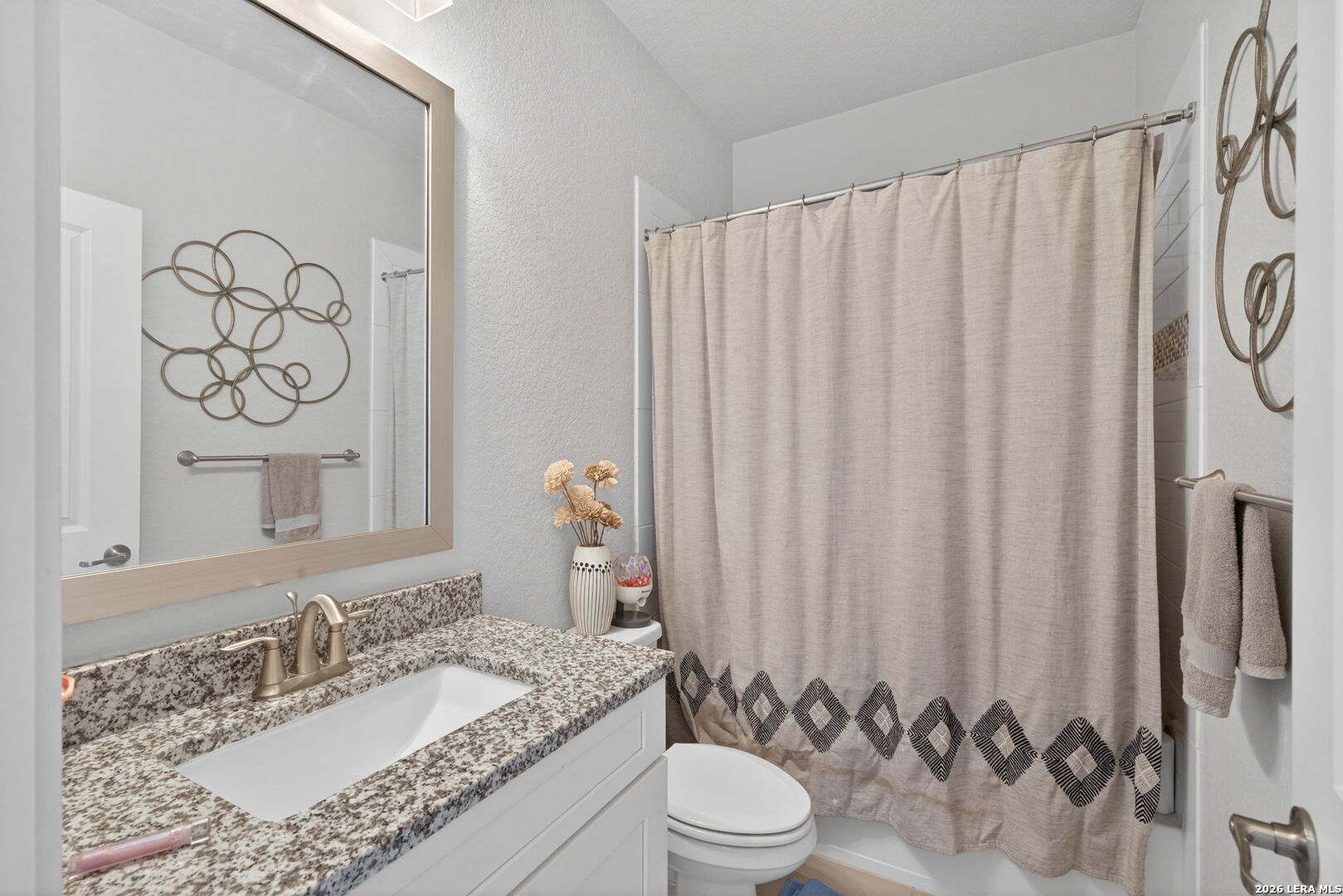 11202 Vance Jackson Road, Unit 17 San Antonio, TX 78230 - Photo 14 of 19 a bathroom with a granite countertop sink and a mirror