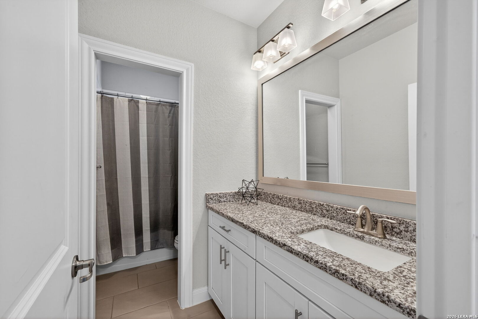 11202 Vance Jackson Road, Unit 17 San Antonio, TX 78230 - Photo 16 of 19 a bathroom with a granite countertop double vanity sink and a mirror