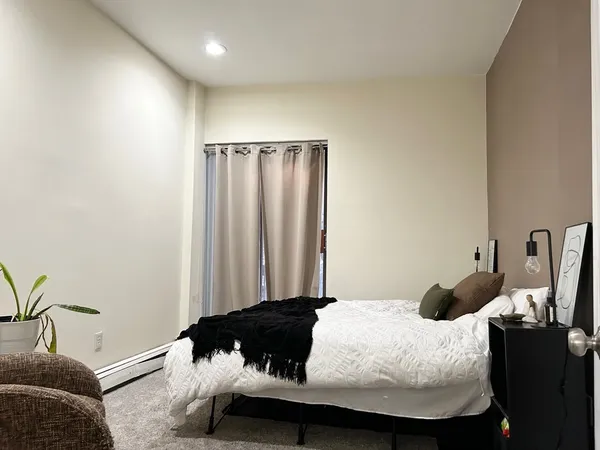 a bedroom with a bed and a potted plant