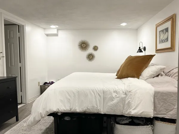 a bedroom with a bed and a painting on the wall