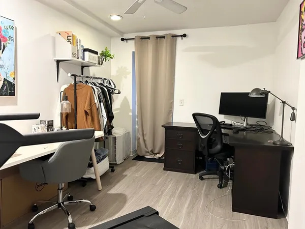 a view of a workspace with furniture and a window