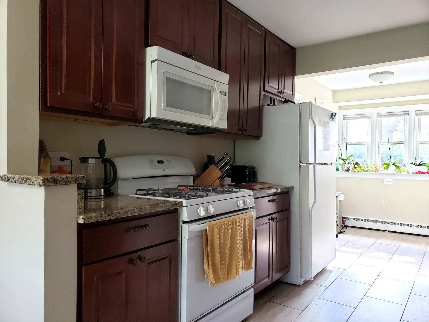 515 Warren Road Glenview, IL 60025 - Photo 8 of 11 a kitchen with stainless steel appliances granite countertop a refrigerator stove a sink and dishwasher with wooden cabinet