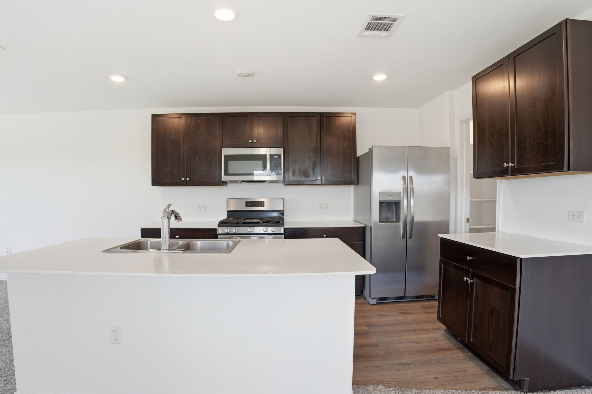 12213 Rising Moon Lane Del Valle, TX 78617 - Photo 5 of 19 a kitchen with kitchen island a sink stainless steel appliances and cabinets