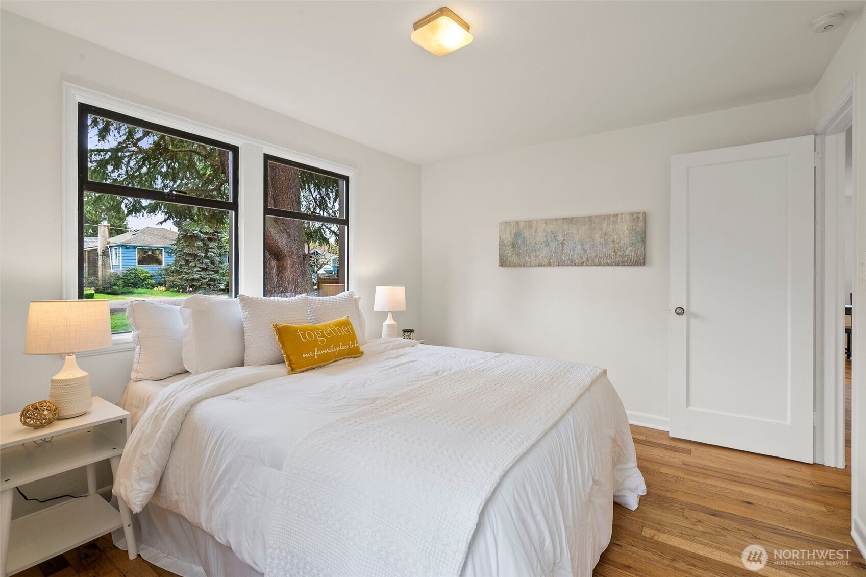 9747 Evanston Avenue North Seattle, WA 98103 - Photo 22 of 34 a bedroom with a bed and wooden floor