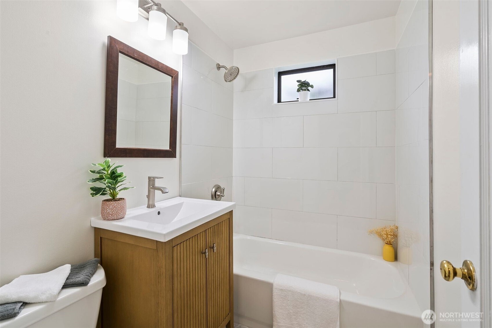 9747 Evanston Avenue North Seattle, WA 98103 - Photo 24 of 34 a bathroom with a sink a mirror and a bathtub