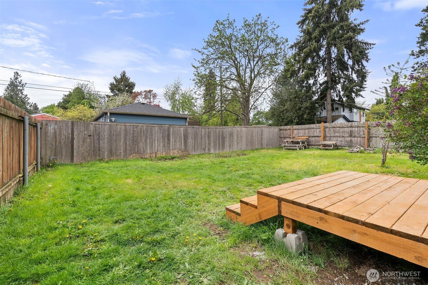 9747 Evanston Avenue North Seattle, WA 98103 - Photo 28 of 34 a view of a backyard with table and chairs and wooden fence