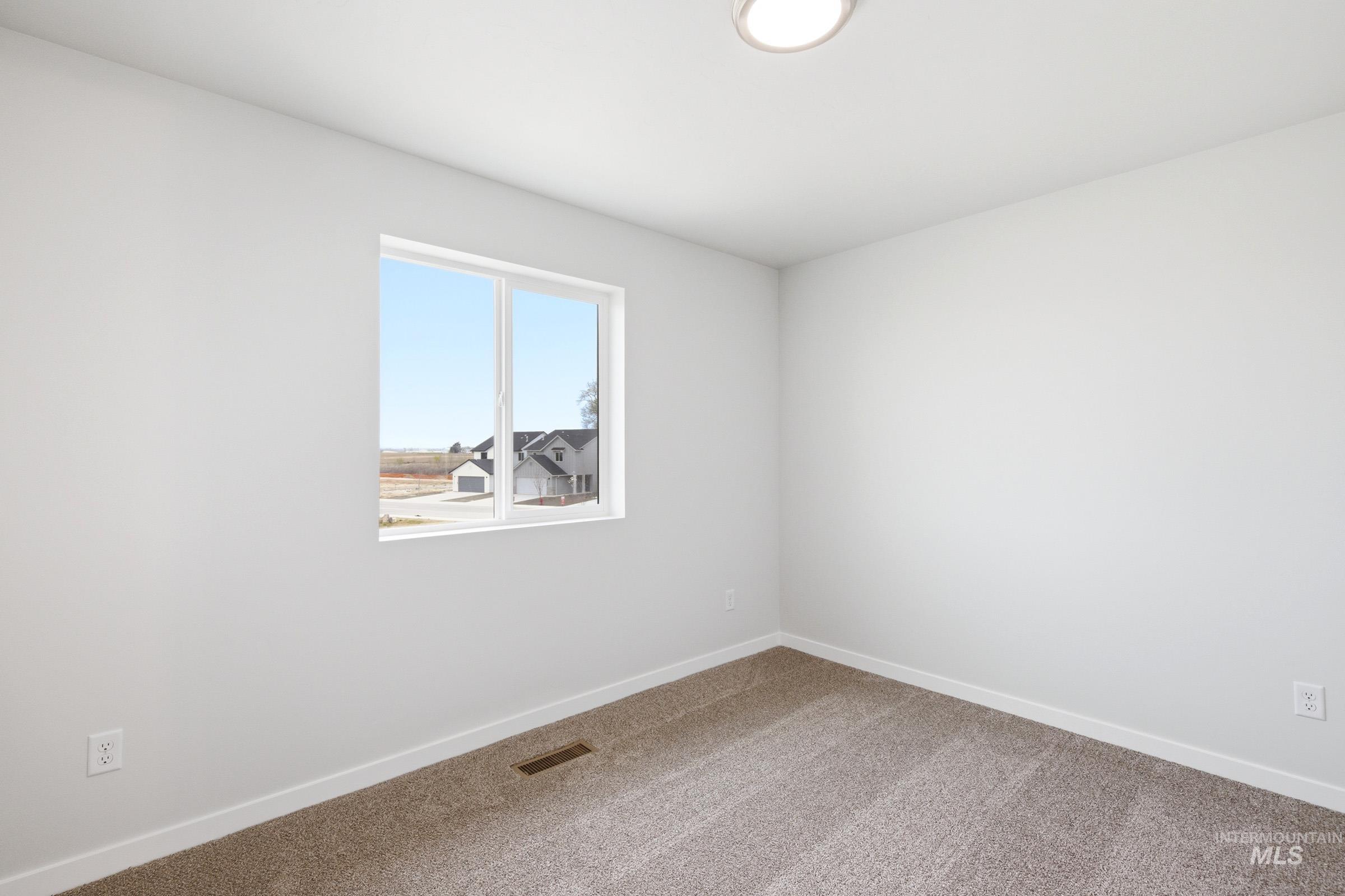 10784 Rutland Street Caldwell, ID 83605 - Photo 12 of 21 Carpeted spare room featuring baseboards