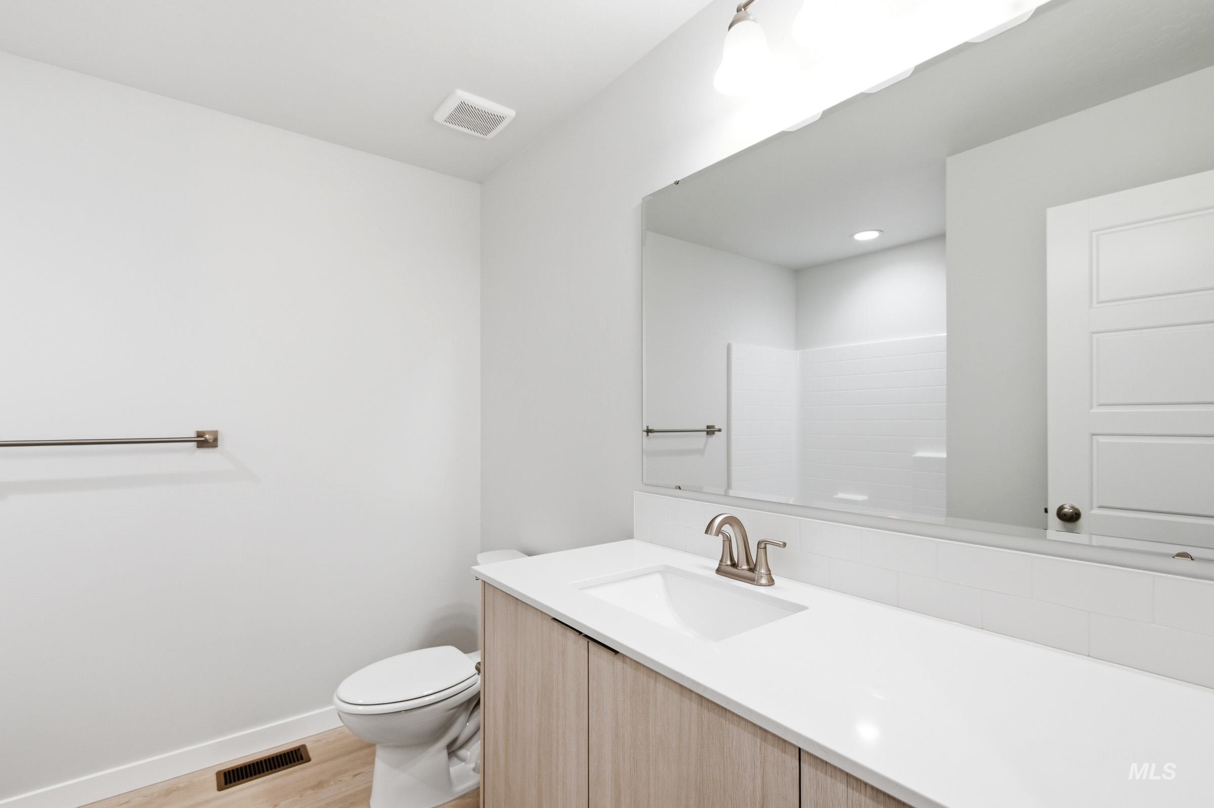 10784 Rutland Street Caldwell, ID 83605 - Photo 14 of 21 Bathroom with vanity, light wood-style flooring, and a shower