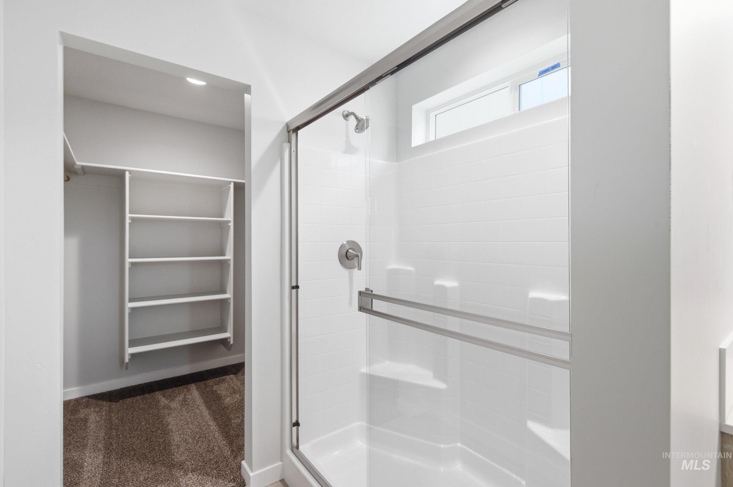 10784 Rutland Street Caldwell, ID 83605 - Photo 17 of 21 Full bathroom featuring a shower stall, dark colored carpet, and a walk in closet