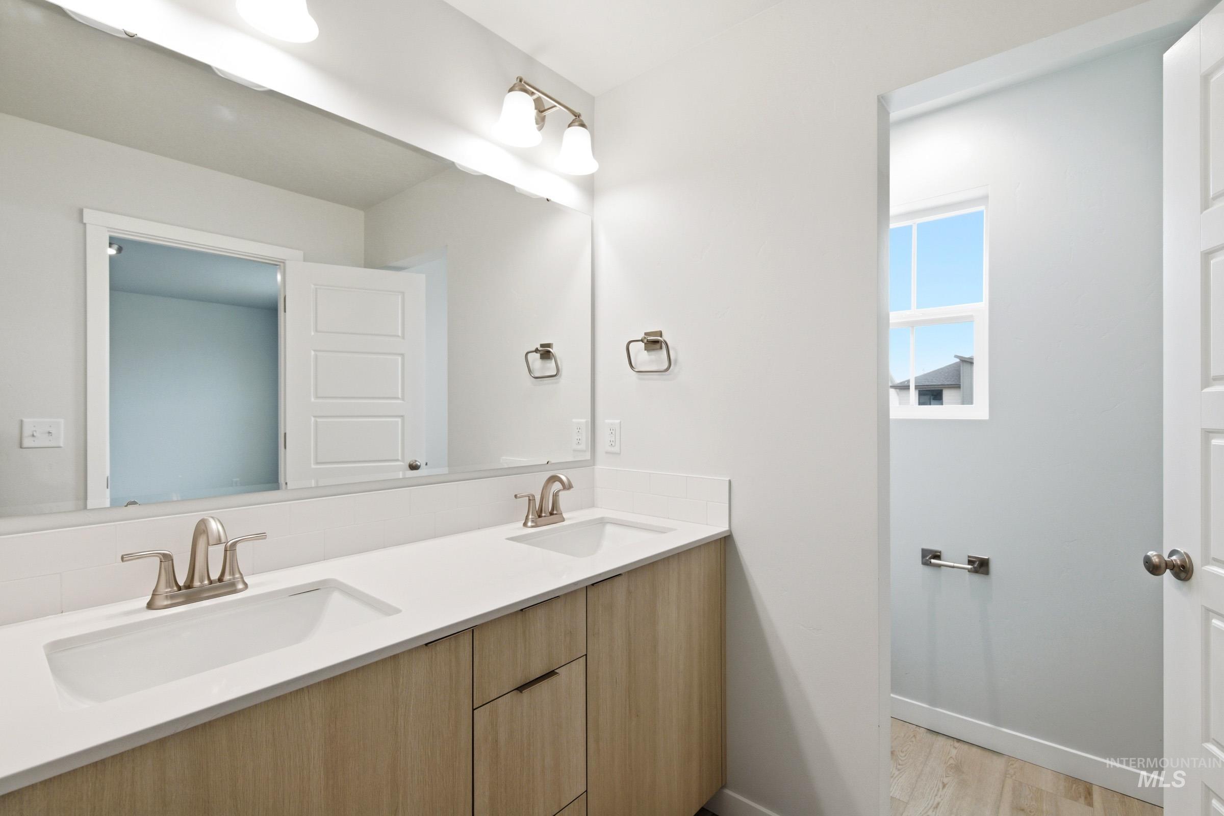 10784 Rutland Street Caldwell, ID 83605 - Photo 18 of 21 Full bathroom with double vanity and light wood-type flooring