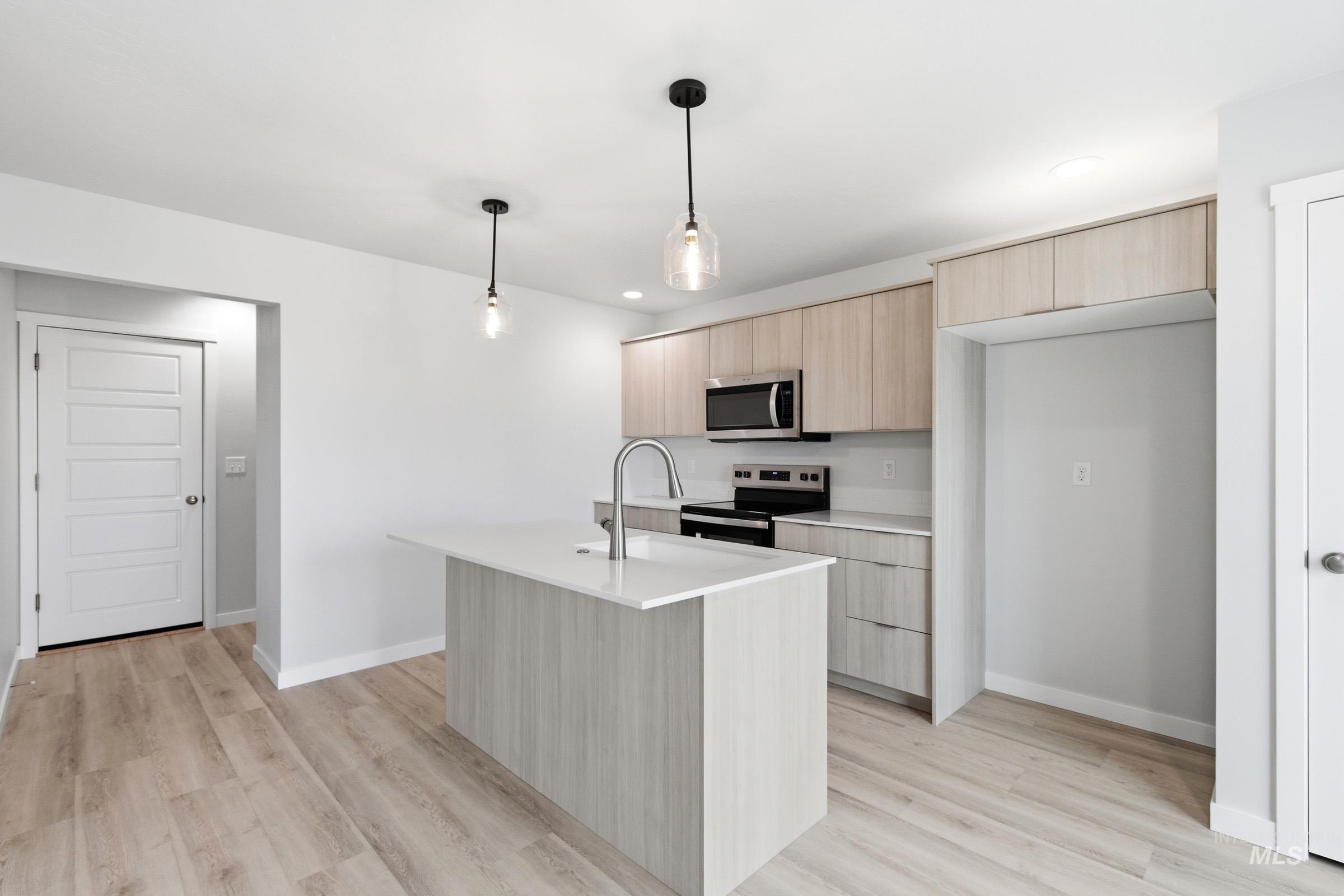 10784 Rutland Street Caldwell, ID 83605 - Photo 3 of 21 Kitchen with light wood finish cabinets, modern cabinets, stainless steel appliances, pendant lighting, and light wood-type flooring
