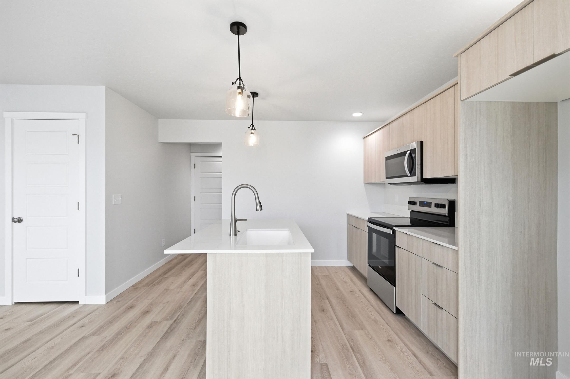 10784 Rutland Street Caldwell, ID 83605 - Photo 5 of 21 Kitchen with light wood finish cabinets, stainless steel appliances, modern cabinets, and a kitchen island with sink