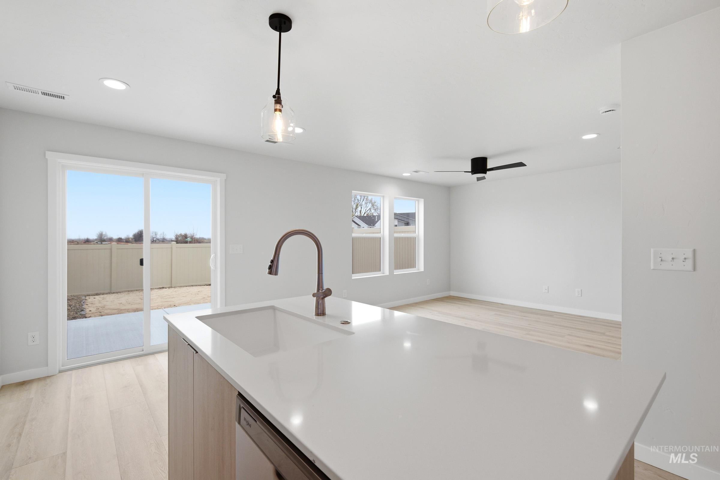 10784 Rutland Street Caldwell, ID 83605 - Photo 21 of 21 Kitchen with pendant lighting, light wood-style flooring, light stone countertops, open floor plan, and dishwashing machine