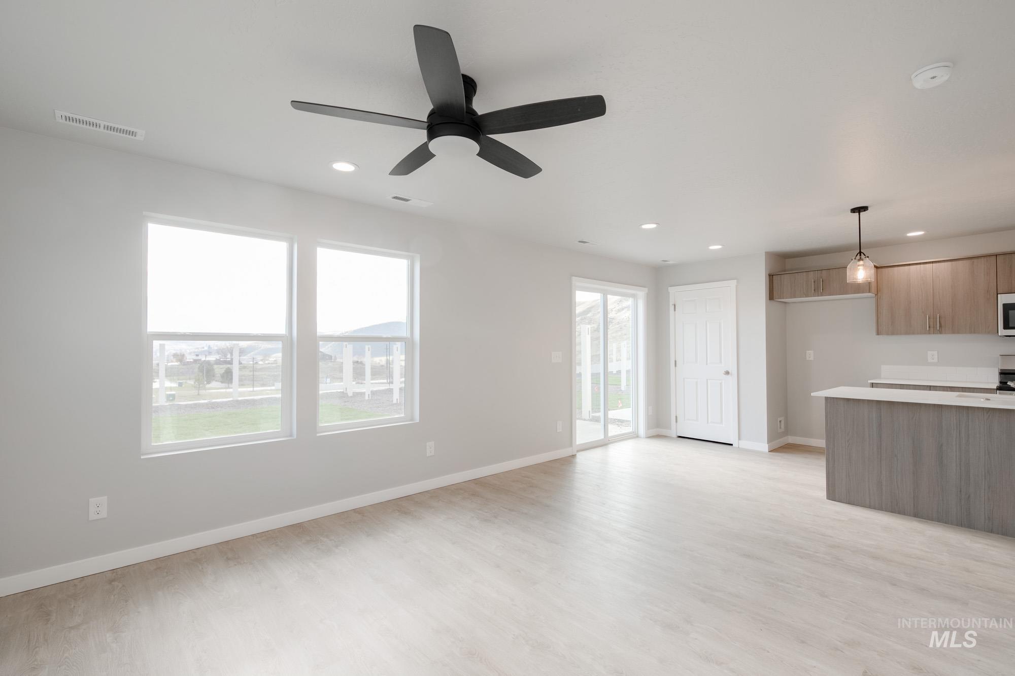 10784 Rutland Street Caldwell, ID 83605 - Photo 8 of 22 Unfurnished living room featuring light wood-type flooring, a ceiling fan, and recessed lighting