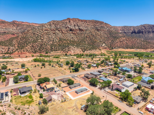 464 Jessop Avenue Hildale, UT 84784 - Photo 73 of 73 Aerial perspective showcasing a residential community nestled against a backdrop of red rock mountains and green vegetation