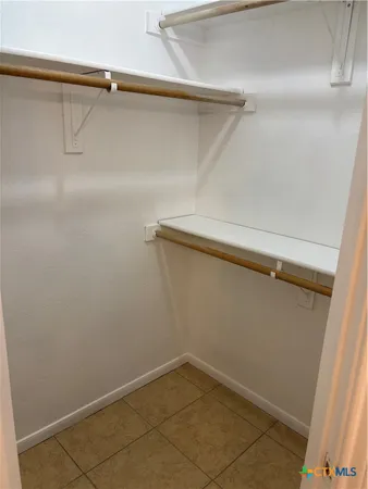 an empty room with windows and ceiling fan