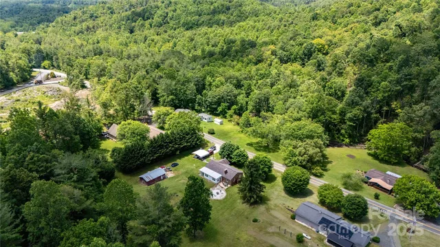 an aerial view of residential house with outdoor space and trees all around