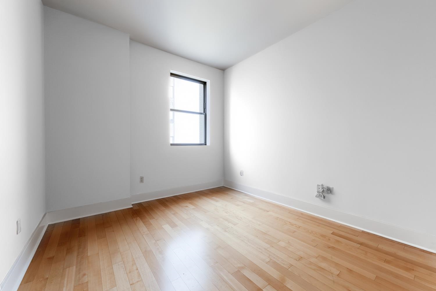 4 Beacon Way, Unit 1511 Jersey City, NJ 07304 - Photo 3 of 17 an empty room with wooden floor and windows