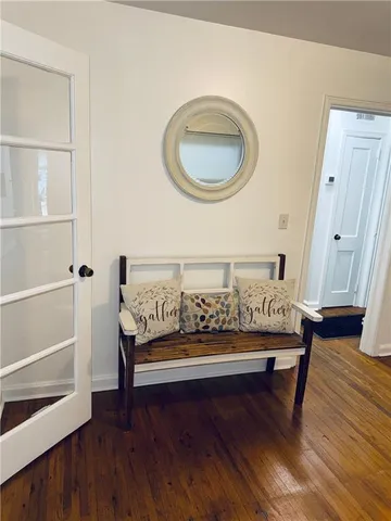 a view of a hallway with wooden floor and stairs