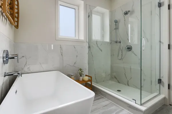 a white bath tub sitting next to a shower