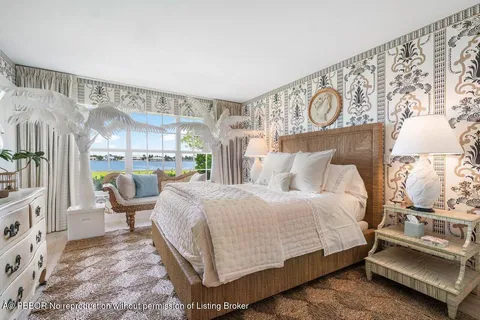 a bedroom with a bed a mirror and lamp on desk