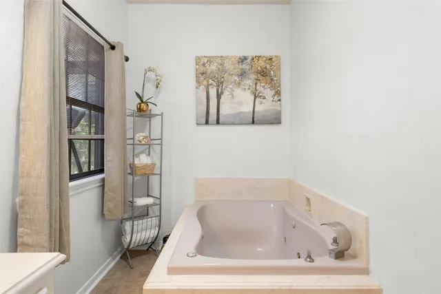 a white bath tub sitting in a bathroom next to a window