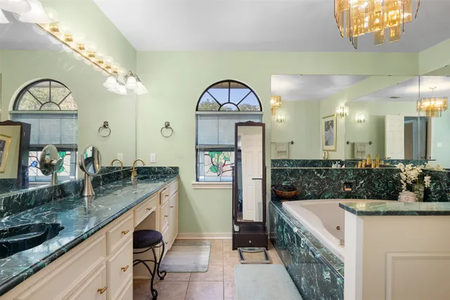 a bathroom with a granite countertop sink a mirror and vanity