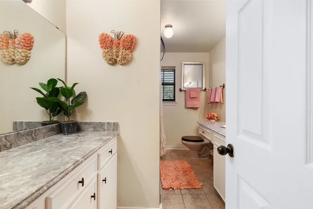 a bathroom with a granite countertop sink a mirror and vanity