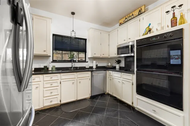 a kitchen with stainless steel appliances a stove a microwave and a sink