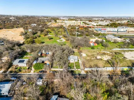 an aerial view of residential house with yard and mountain view in back