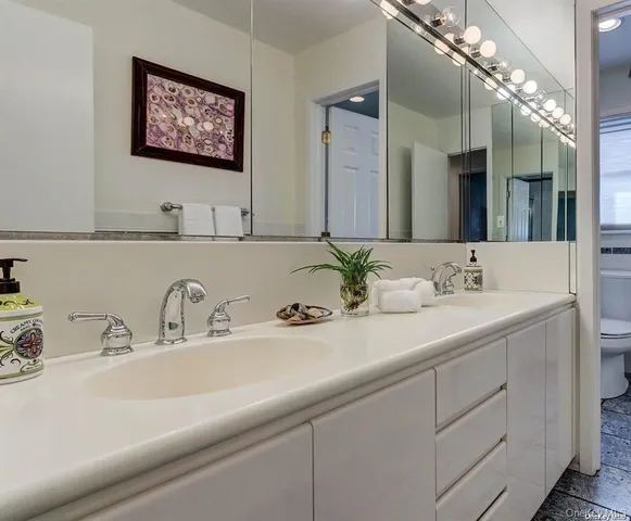 a bathroom with double sink and a mirror