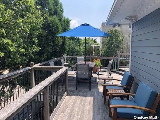a view of deck with furniture and barbeque oven with wooden floor