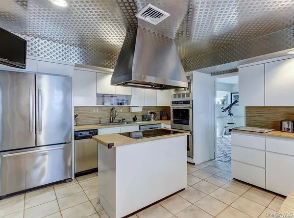 a kitchen with stainless steel appliances granite countertop a sink a stove and a refrigerator